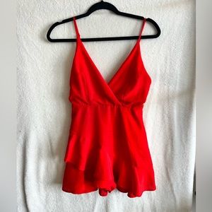 Red romper by the clothing company. Slightly worn.